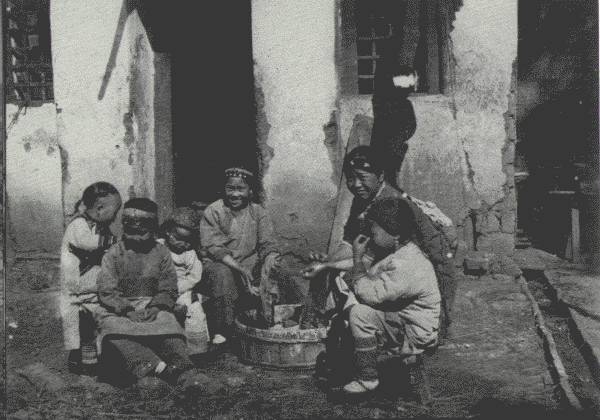 WASH DAY AMONG THE CHILDREN  Scene in the school grounds of the mission at Tongch'uanfu, the "City of the Eastern Streams"—and a very happy little band they are.