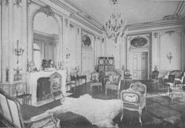 The mantel with its great glass reaching to the cornice, the wall panels, paintings over the doors, and beautiful furniture, all show the spirit of the best Louis XV period. The fur rug is an anachronism and detracts from the effect of the room.