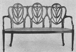 A modern Hepplewhite settee, showing the draped scarf  carving he used so much.