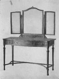 The modern style of mirror is brought into harmony with the eighteenth century dressing-table by means of carving.