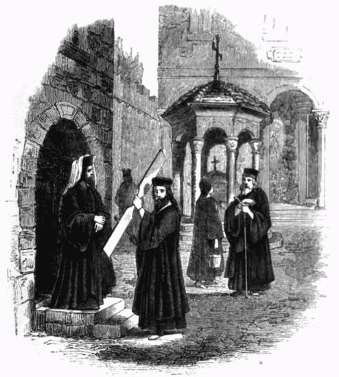 From a Sketch by R. Curzon. Interior of the Court of a Greek Monastery. A monk is calling the congregation to prayer, by beating a board called the simandro (σιμανδρο) which is generally used instead of bells.