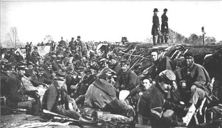 Assaults on fortified positions were costly, but here at Petersburg war-weary infantrymen await their turn for another charge against the Confederate works. Fourteen out of every hundred would fall.