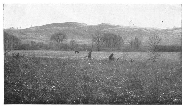 Fig. 34. Hummocky moraine hills in the background and a level gravel plain—an ancient glacial-stream flood-plain—in foreground.