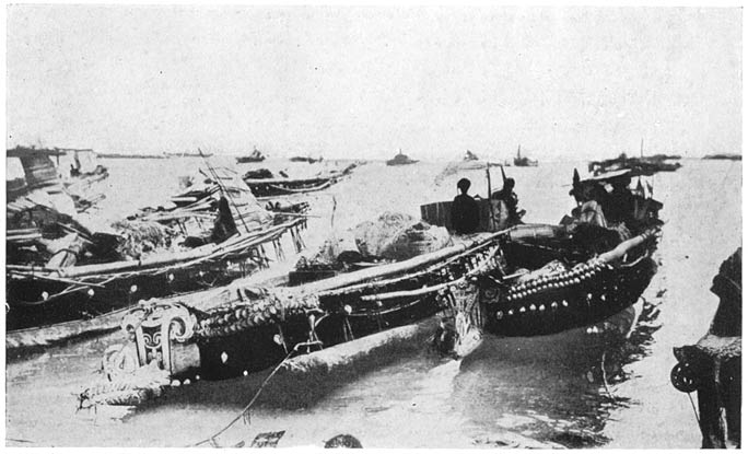 Some Canoes Moored on the Shallow Lagoon near the Shore.