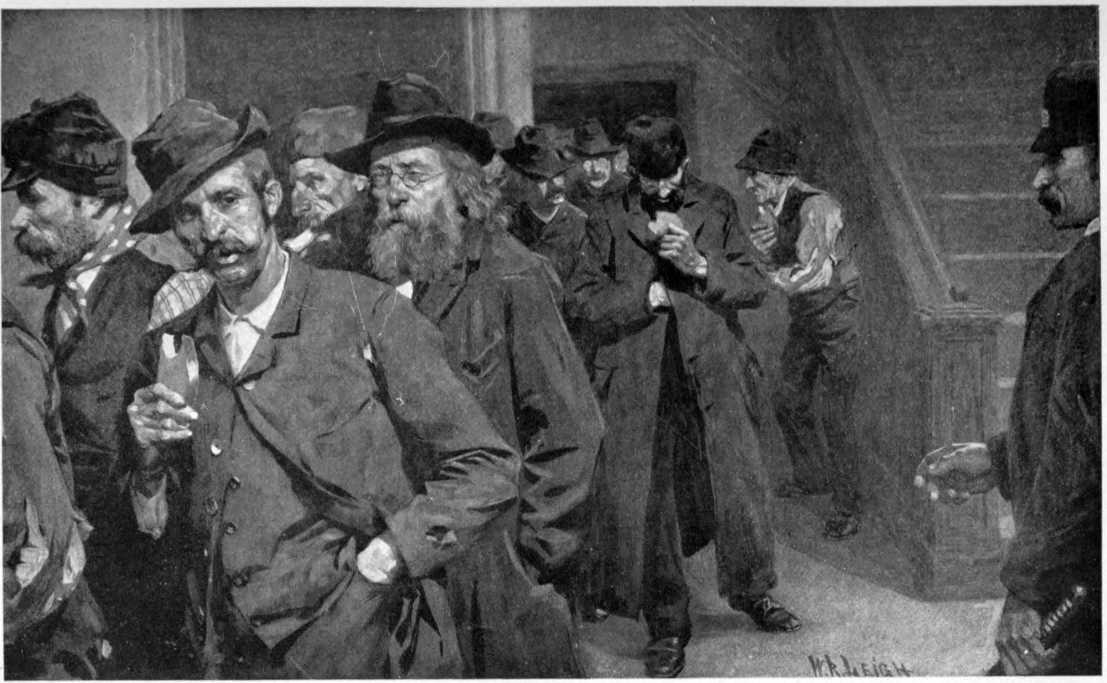 A line of men in worn out clothes exiting through a door watched by a policeman. Many of them are eating bread.