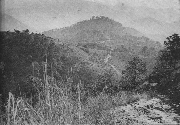 THE SWITZERLAND OF WESTERN CHINA

To travel in China is easy over country like this, granted that the
traveler sticks to the main road, sample of which is seen at lower
right.